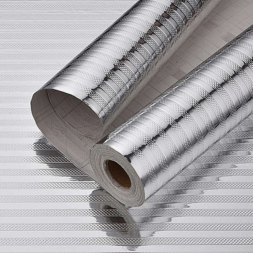 Roll of self-adhesive aluminum foil contact sheets lying on a striped surface.
