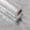 Roll of silver self-adhesive aluminum foil wall decals lying on a reflective surface.