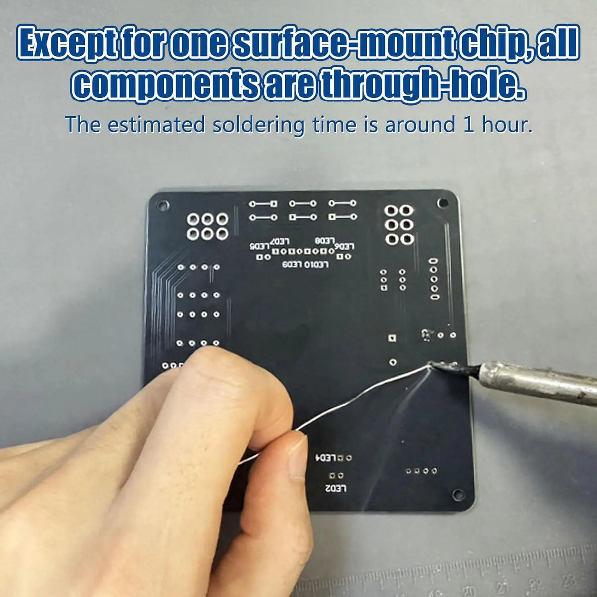 A hand is inserting a wire into a through-hole electronic kit board for soldering.