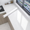 A roll of pearlescent PVC self-adhesive wall stickers displayed on a white countertop near a window.