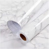 Roll of pearlescent PVC self-adhesive wall stickers for home decor shown on a marble surface.