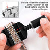 A hand is using a black tool to remove a watch pin, with an arrow indicating the direction of removal on the band.