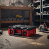 A red heavy duty modular tool storage case lying on a concrete floor in a workshop setting.
