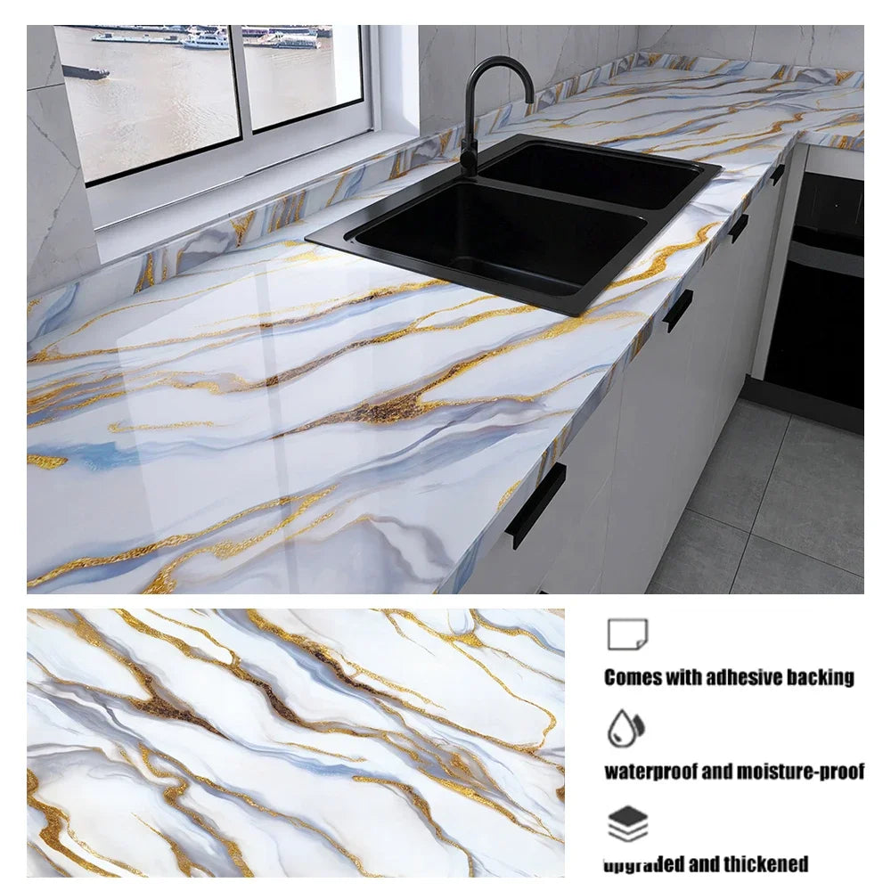 Schwarze Küchenspüle mit weißer Arbeitsplatte und Marmormuster mit goldenen Adern.