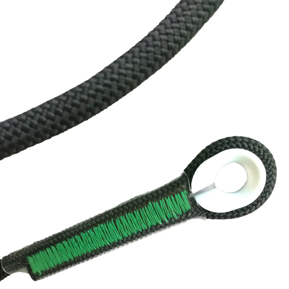 Un gros plan d'une sangle noire en corde avec une touche verte, utilisée pour l'escalade et l'équipement extérieur.