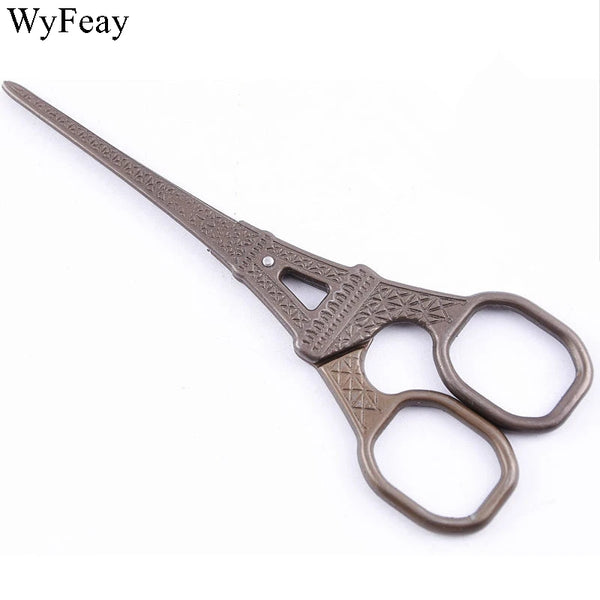 A pair of vintage floral embroidery tailor scissors with a dark brown handle and metal blades.