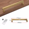 A modern golden brass cabinet handle shown in a close-up view against a wooden surface, with dimensions provided.