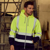 A man wearing a bright yellow reflective winter zipper hoodie in a warehouse setting.