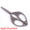 A pair of vintage floral embroidery tailor scissors with a dark metal finish.