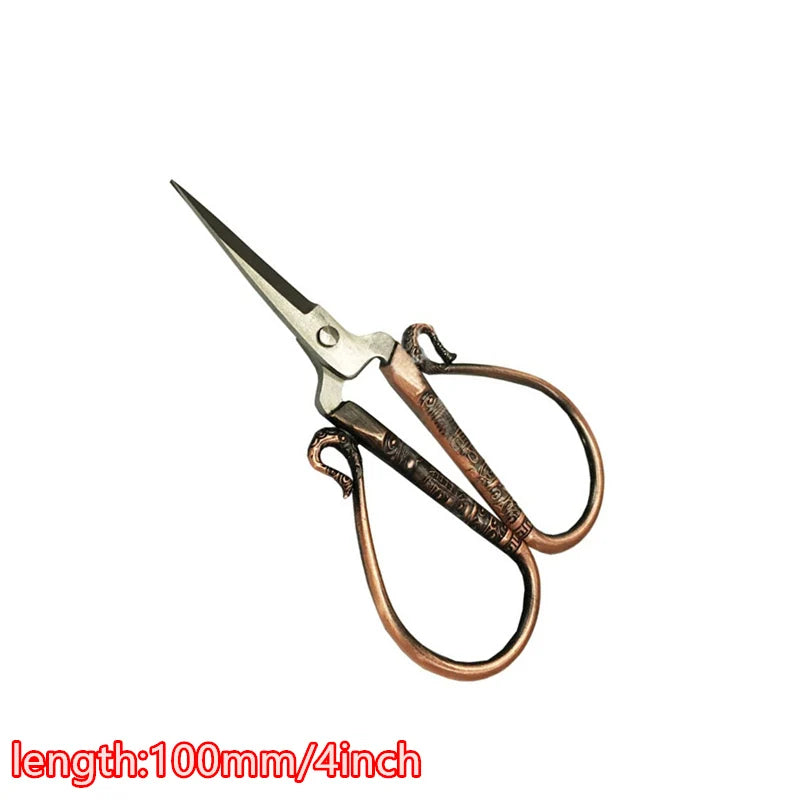 Vintage floral embroidery tailor scissors with a brass finish and a sharp point.