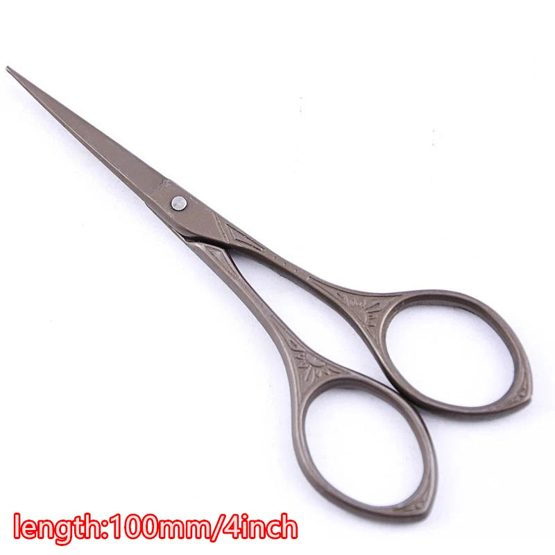 A pair of vintage floral embroidery tailor scissors with a silver-toned handle and metal blades.
