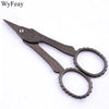 Vintage floral embroidery tailor scissors with dark metal handles and pointed blades