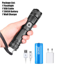Una mano sostiene una linterna táctica negra recargable LED y accesorios, incluyendo batería y cargador.