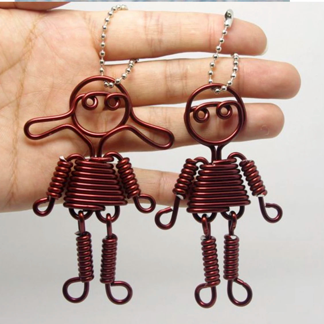 Paar anodisierter Metall-Schmuck-Ohrringe in rostbrauner Farbe mit stilisiertem Figuren-Design