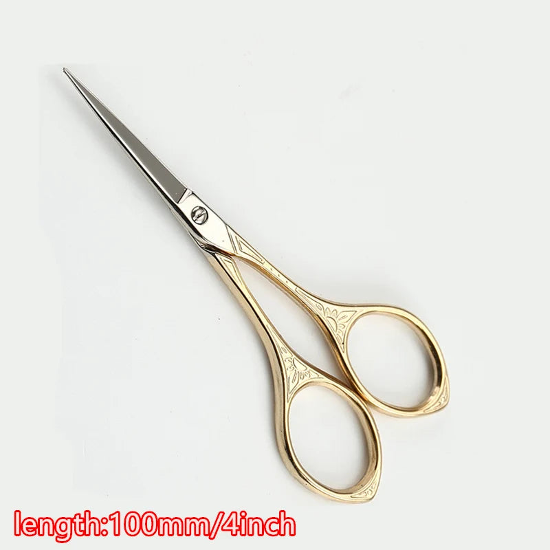 Gold-toned tailor scissors with floral embroidery detailing, shown against a white background.