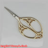 Gold-toned tailor scissors with a floral pattern design and a pointed tip.