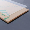A clear acrylic sheet is placed on a light brown wooden base, showing the text CAST ACRYL