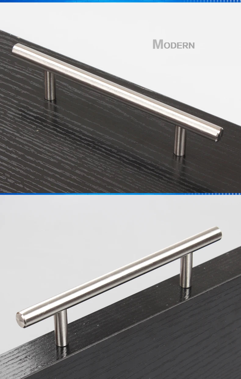 A modern stainless steel cabinet pull handle mounted on a dark wood surface.