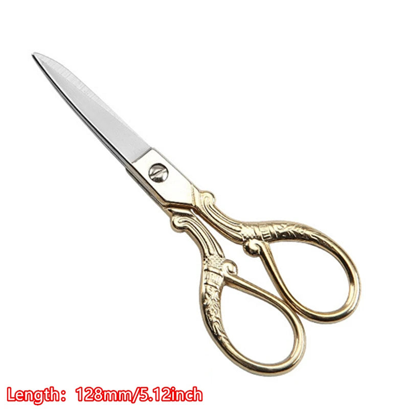 A pair of vintage floral embroidery tailor scissors with a silver blade and gold-toned handles.