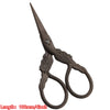 A pair of vintage floral embroidery tailor scissors with a pointed blade and curved handles.