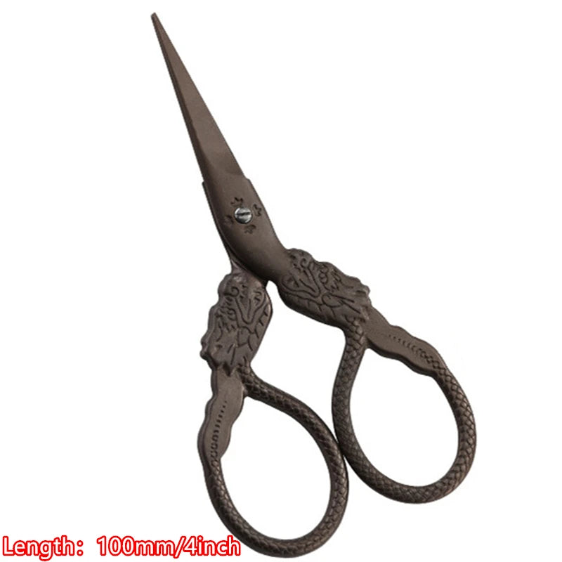A pair of vintage floral embroidery tailor scissors with a pointed blade and curved handles.