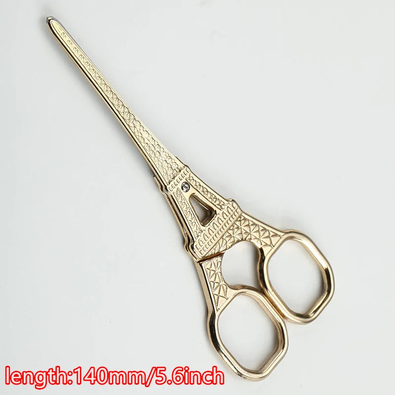 A pair of vintage gold-toned tailor scissors with floral embroidery detailing.