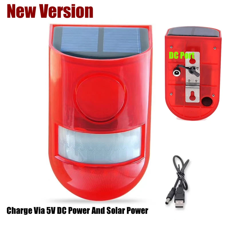 A red solar motion sensor security alarm unit with a glass lens and a DC port connector.