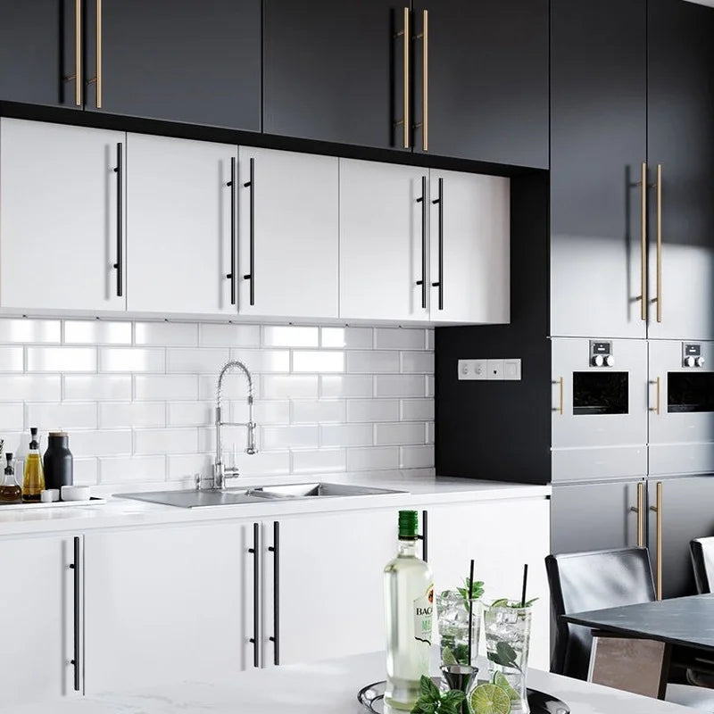 Modern kitchen cabinetry featuring white doors and black accents with stainless steel door pull handles.