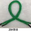A green gift wrapping rope is shown tied in a loop and crossed, with black tips visible.