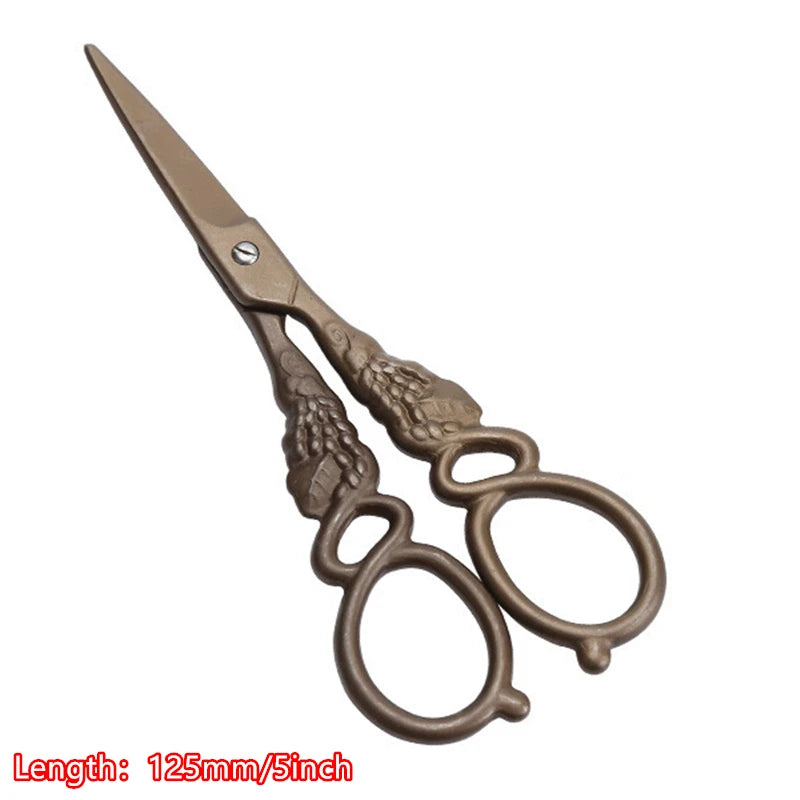 A pair of vintage floral embroidery tailor scissors with a bronze finish.