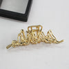Elegant gold S-shaped metal hair clips displayed on a white background.