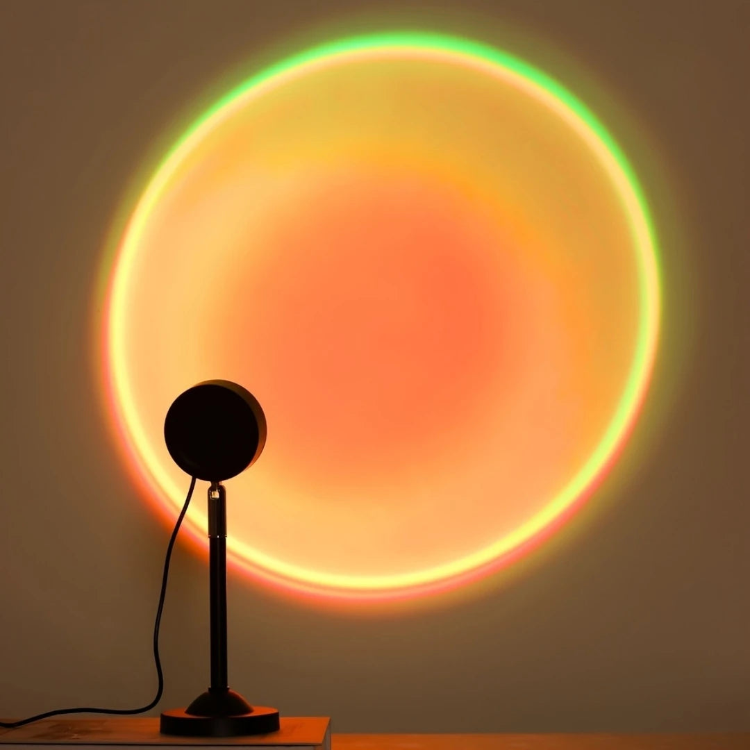 A multi-color LED sunset projector night light casts a vibrant, glowing circle onto a wall.
