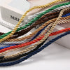 A collection of multi-colored adjustable polyester craft cord strands in various shades including gold, green, brown, blue, a