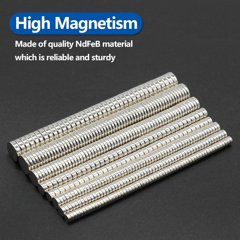 A collection of silver neodymium fridge magnets arranged in a diagonal line on a dark surface.