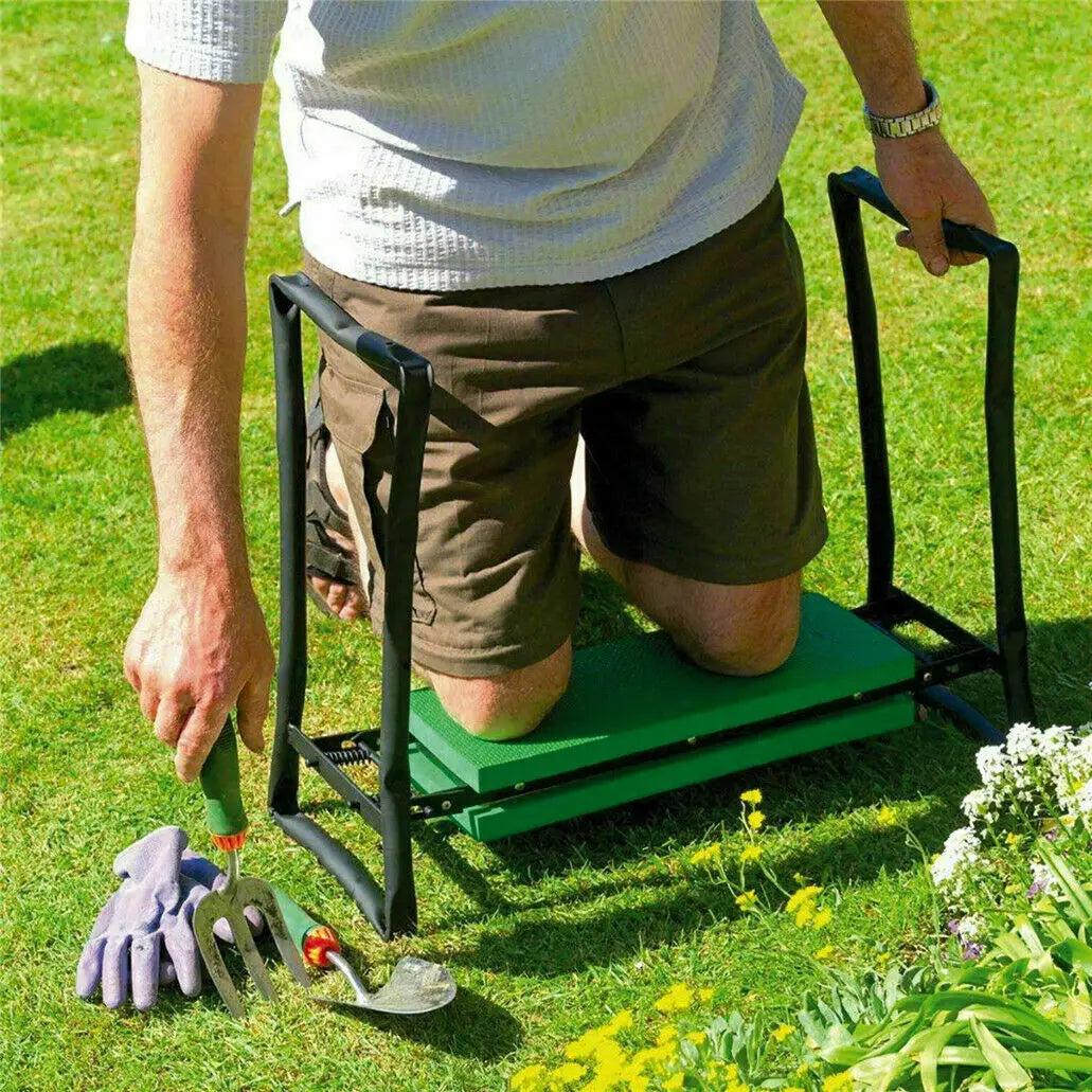 Eine Person benutzt einen schweren Gartenhocker, um im Gras zu knien, mit Gartengeräten in der Nähe.