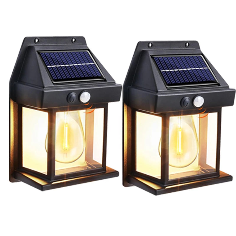 A pair of black solar motion sensor outdoor wall lights with integrated solar panels and visible light bulbs.