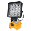 A black LED work light is mounted on a yellow battery pack for illuminating power tools.