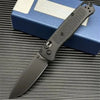 A black folding pocket knife with a textured handle rests on a blue box.