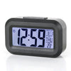 Reloj de alarma digital LED negro mostrando las 12:59, con fecha y temperatura.