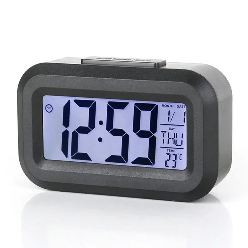 Reloj de alarma digital LED negro mostrando las 12:59, con fecha y temperatura.