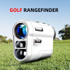 A silver golf rangefinder device is shown resting on green grass under a blue sky.