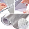 Nahaufnahme von Aluminiumfolien-Wandstickern, die für Küche und Dekoration geschnitten und gerollt werden.