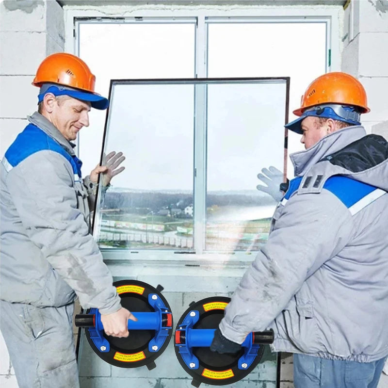 Deux ouvriers inspectent un levier à ventouse pour verre et carrelage contre une fenêtre.