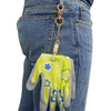 A bright yellow and green heavy duty metal glove clip attached to a denim jean pocket.