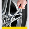 A hand is holding an adjustable square drive socket bit set tool near a car wheel hub.