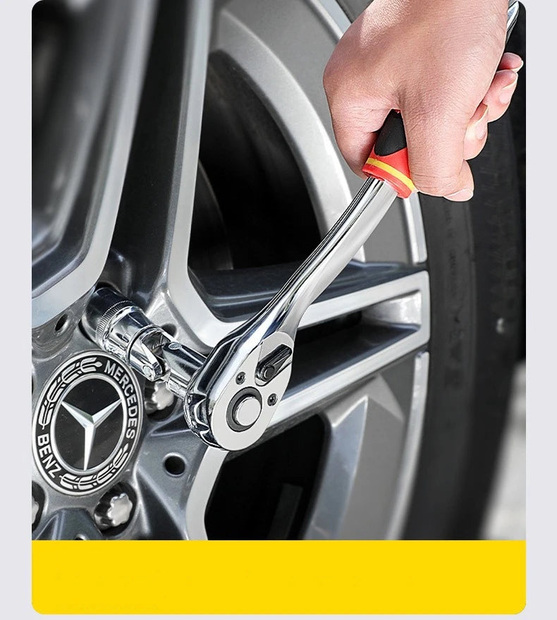 A hand is holding an adjustable square drive socket bit set tool near a car wheel hub.