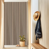 A vertical wooden slat wall design with a light beige wall and a wooden hanger visible in the foreground.