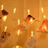 String lights with small yellow LED bulbs are strung across a white wall for decoration.