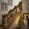 A wooden staircase decorated with an LED rattan garland and Christmas ornaments.
