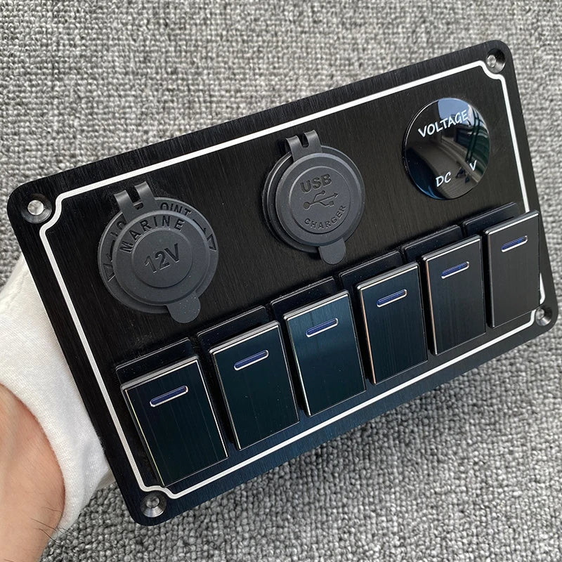 Panneau de commutateur en aluminium noir avec indicateurs de tension USB et CC et plusieurs boutons de commutation.